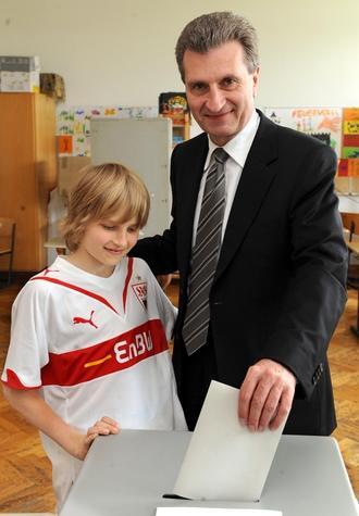 Der baden-württembergische Ministerpräsident Günther Oettinger (CDU) steckt am Sonntag neben seinem Sohn Alexander den Stimmzettel für die Europawahl in der Stuttgarter Vogelsang-Schule in die Wahlurne. Der baden-württembergische Ministerpräsident Günther Oettinger (CDU) steckt am Sonntag neben seinem Sohn Alexander den Stimmzettel für die Europawahl in der Stuttgarter Vogelsang-Schule in die Wahlurne.